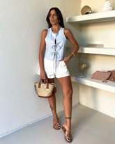 Blusa 'Gracielle' en color celeste, diseño sin mangas con detalle de cordón ajustable en la parte frontal, ideal para looks elegantes y casuales.