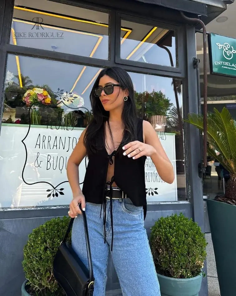 Blusa negra ajustable para mujer con lazos frontales, estilo elegante de KIKE RODRIGUEZ.