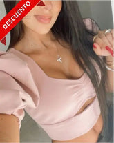 Mujer usando una blusa rosa con mangas abullonadas en descuento, destacando un estilo elegante y femenino ideal para cualquier ocasión.