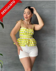 Mujer con una blusa de cuadros amarillos y volantes en descuento, mostrando un estilo alegre y moderno, perfecta para cualquier ocasión.