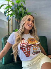 Camiseta blanca con el texto "LOVE" en diseño floral, disponible en promoción especial de 3 por $129,900. Perfecta para un estilo casual y moderno, presentada por KIKE RODRIGUEZ.