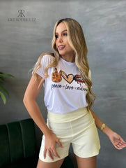 Camiseta blanca con diseño dorado de "Peace Love Melanin", en promoción especial de 3 por $129,900 en KIKE RODRIGUEZ. Ideal para expresar estilo y un mensaje positivo.