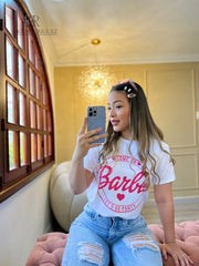 Camiseta blanca con diseño de Barbie "Let's Go Party" en promoción especial de 3 por $129,900. Ideal para un look casual y alegre, disponible en KIKE RODRIGUEZ.