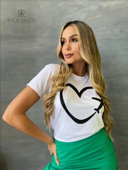 Camiseta blanca con diseño de corazón y avión en promoción especial de 3 por $129,900, disponible en KIKE RODRIGUEZ. Ideal para los amantes de los viajes y la moda.