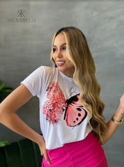 Camiseta blanca con diseño de mariposa floral en promoción especial de 3 por $129,900, disponible en KIKE RODRIGUEZ. Ideal para añadir un toque de naturaleza a tu estilo.