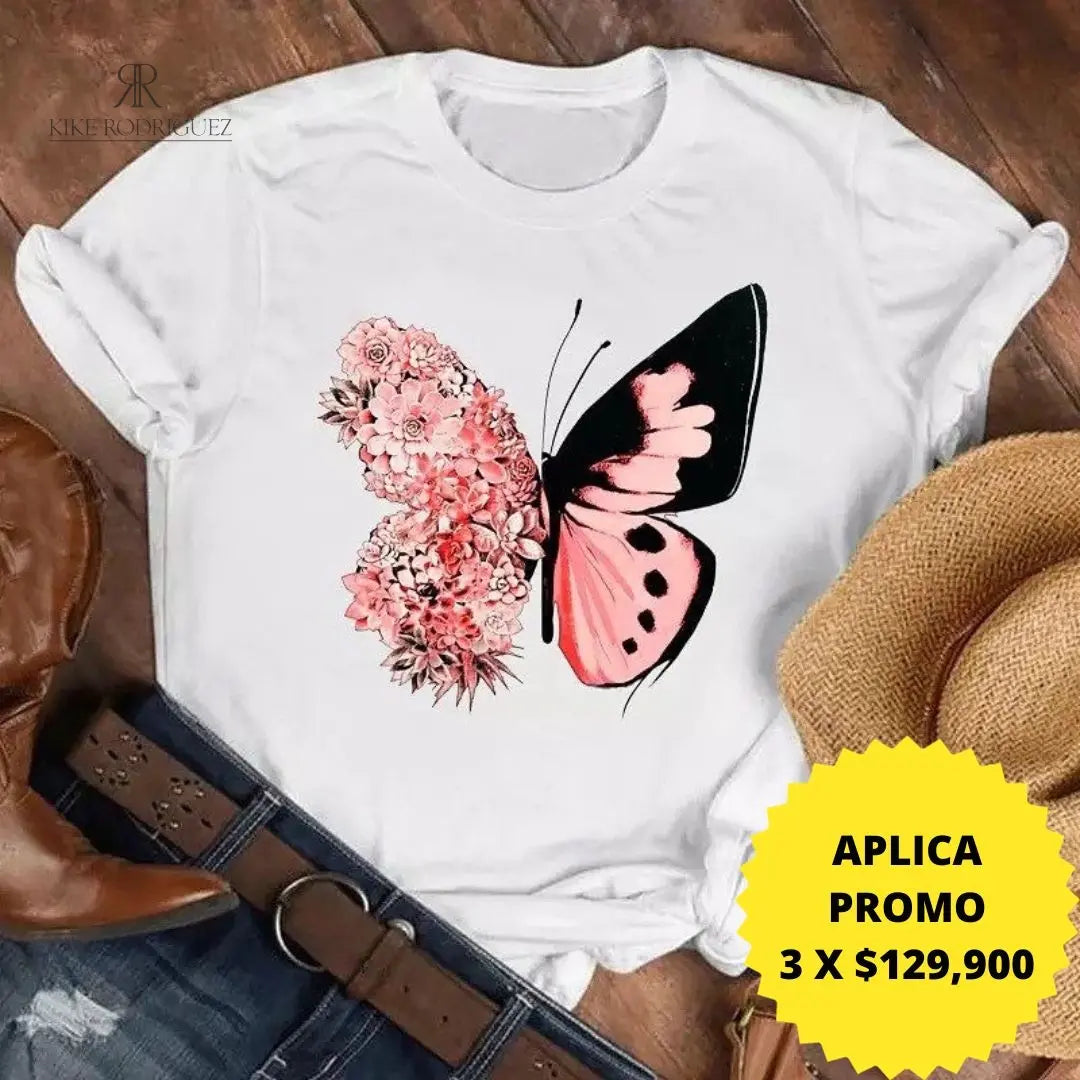 Camiseta blanca con diseño de mariposa floral en promoción especial de 3 por $129,900, disponible en KIKE RODRIGUEZ. Ideal para añadir un toque de naturaleza a tu estilo.