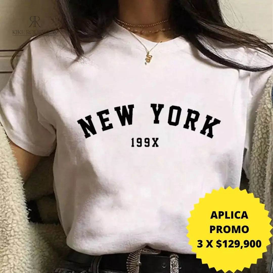 Camiseta blanca con estampado "New York 199X", ideal para un look casual y moderno. Disponible en promoción de 3 por $129,900 en KIKE RODRIGUEZ. Compra ahora y marca tendencia.