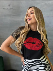 Camiseta negra con diseño de labios rojos brillantes en promoción especial de 3 por $129,900, disponible en KIKE RODRIGUEZ. Ideal para un look glamuroso y llamativo.