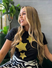 Camiseta negra con diseño de estrellas doradas de brillo, disponible en promoción especial de 3 por $129,900 en KIKE RODRIGUEZ. Ideal para un estilo glamuroso y moderno.