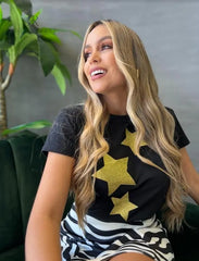 Camiseta negra con diseño de estrellas doradas de brillo, disponible en promoción especial de 3 por $129,900 en KIKE RODRIGUEZ. Ideal para un estilo glamuroso y moderno.