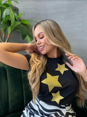 Camiseta negra con diseño de estrellas doradas de brillo, disponible en promoción especial de 3 por $129,900 en KIKE RODRIGUEZ. Ideal para un estilo glamuroso y moderno.