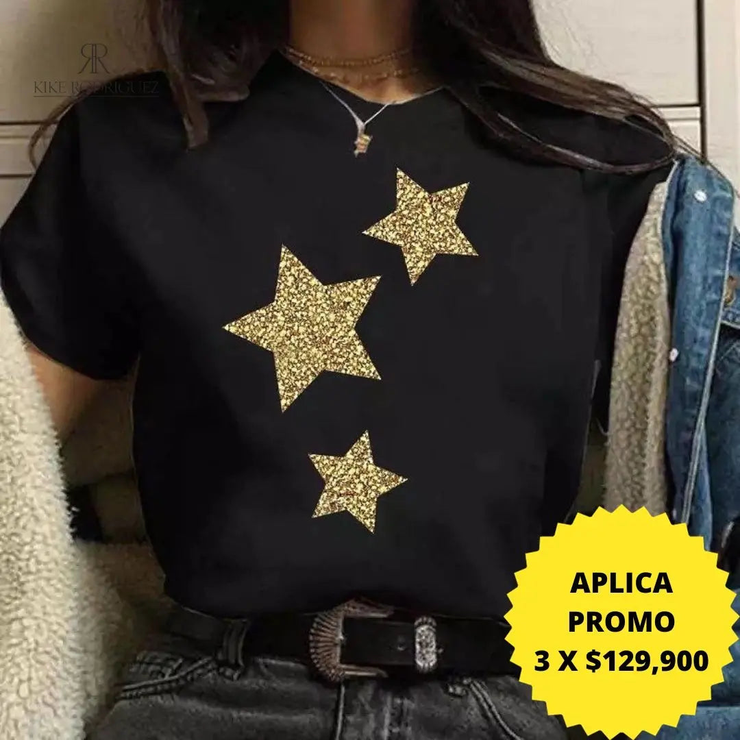 Camiseta negra con diseño de estrellas doradas de brillo, disponible en promoción especial de 3 por $129,900 en KIKE RODRIGUEZ. Ideal para un estilo glamuroso y moderno.