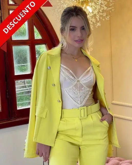 Conjunto de traje amarillo con blazer y pantalón, combinado con un delicado top blanco de encaje. Perfecto para un look sofisticado y moderno, ideal para eventos especiales y para destacar con estilo.