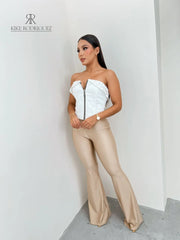Mujer vistiendo un corset blanco con cierre frontal y detalle de tachuelas, ideal para un look atrevido y moderno. Disponible en KIKE RODRIGUEZ.