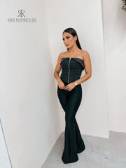 Mujer vistiendo un corset negro con cierre frontal y detalle de tachuelas, ideal para un look atrevido y moderno. Disponible en KIKE RODRIGUEZ.