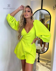 Modelo luciendo un elegante enterizo en color neon con mangas abullonadas y escote en V, ideal para destacar en cualquier ocasión.
