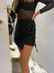 Falda asimétrica negra con detalles de cordón en el lateral, perfecta para un look sofisticado y moderno.
