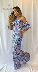 Modelo luciendo un moderno enterizo con estampado azul y rosa, escote halter y mangas abullonadas, ideal para destacar en cualquier evento.