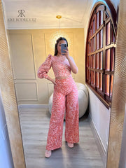 Mujer luciendo un top asimétrico con estampado floral en tonos rosados, con una manga larga abullonada, ideal para un look elegante y moderno.