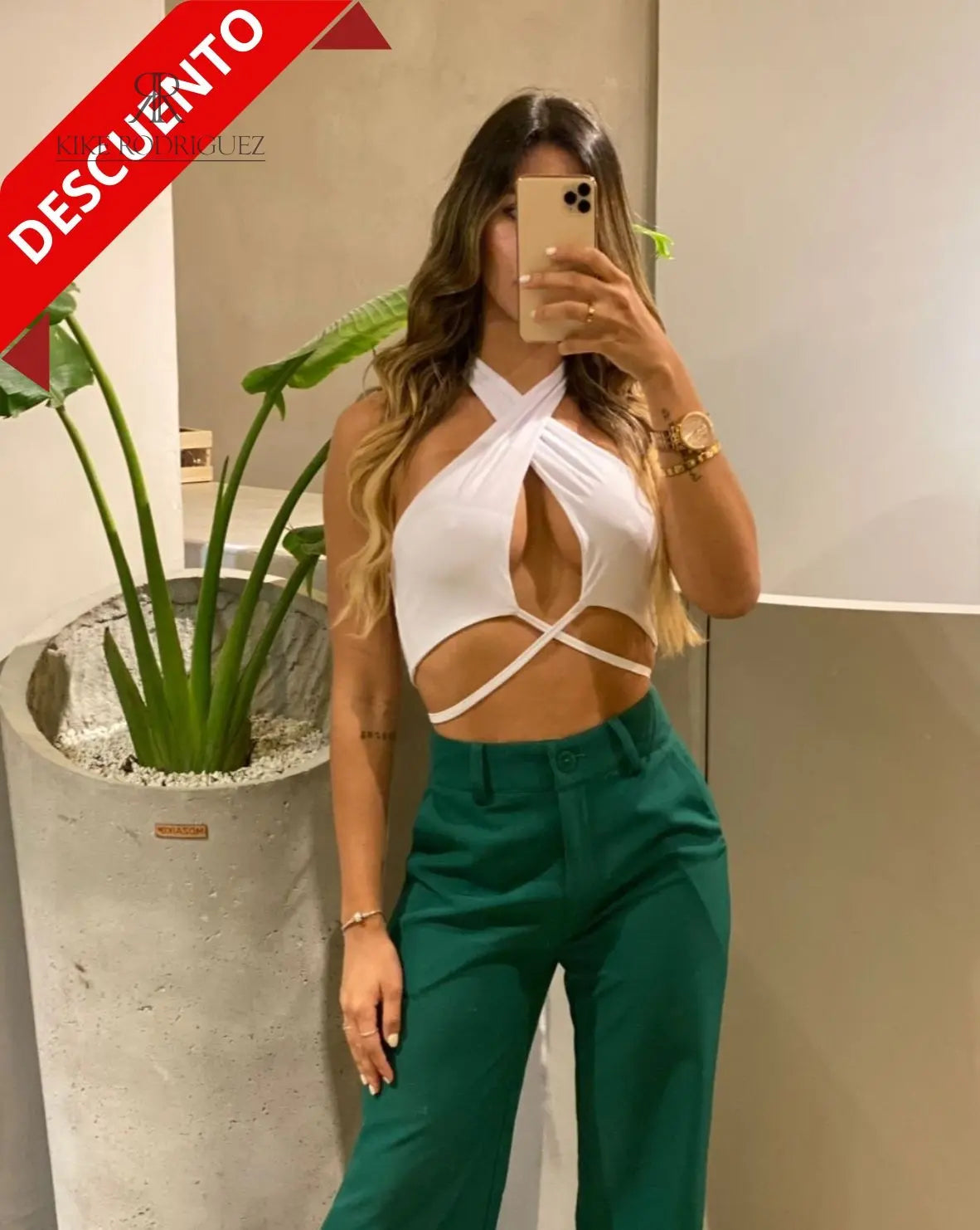 Mujer vistiendo un top blanco cruzado con tirantes de KIKE RODRIGUEZ, ideal para un look moderno y atrevido. Perfecto para destacar en eventos y ocasiones especiales.