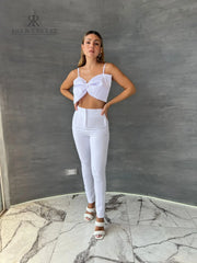 Mujer luciendo un top blanco con lazo frontal, ideal para un look elegante y sofisticado. Perfecto para cualquier ocasión especial.