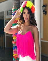 Mujer usando un top fucsia con flecos, ideal para un estilo audaz y moderno en cualquier ocasión.