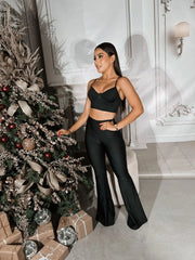 Mujer luciendo un top negro con tirantes y diseño elegante, ideal para cualquier ocasión. Disponible en KIKE RODRIGUEZ.