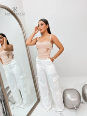 Mujer luciendo un top nude con tirantes y diseño lateral, perfecto para un look sofisticado y elegante. Disponible en KIKE RODRIGUEZ.