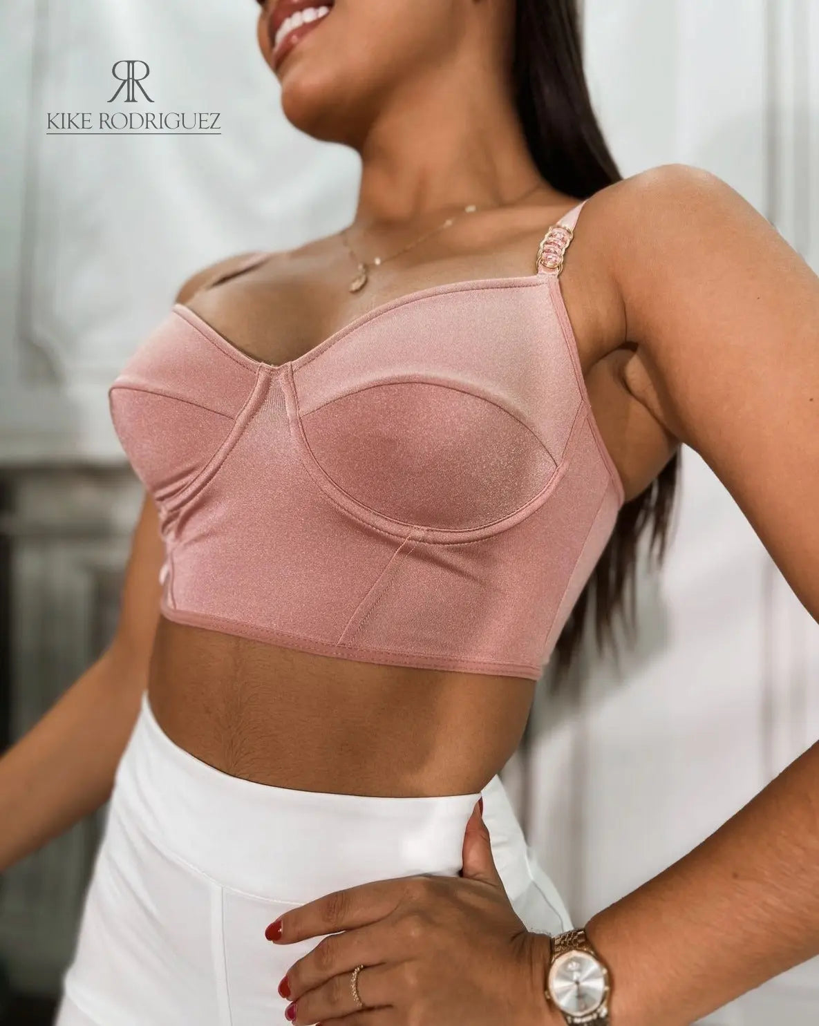 Modelo luciendo un elegante top rosa con tirantes finos, ideal para destacar en eventos y celebraciones. Perfecto para un look sofisticado y moderno.