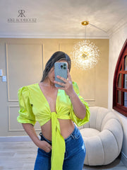 Top verde neón satinado con mangas abullonadas, perfecto para destacar en eventos especiales, combinado con jeans para un look moderno y llamativo.