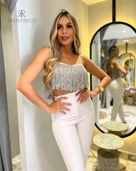 Mujer vistiendo un top de flecos plateado de KIKE RODRIGUEZ, ideal para noches de fiesta y eventos especiales, que añade un toque de glamour y brillo a su atuendo.