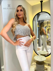 Mujer vistiendo un top de flecos plateado de KIKE RODRIGUEZ, ideal para noches de fiesta y eventos especiales, que añade un toque de glamour y brillo a su atuendo.