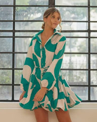 Mujer vistiendo un vestido camisero verde y blanco estampado de KIKE RODRIGUEZ, perfecto para un look casual y chic, ideal para diversas ocasiones.