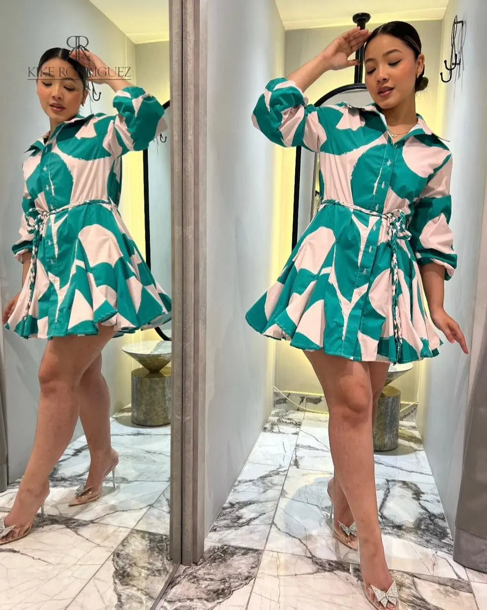 Mujer vistiendo un vestido camisero verde y blanco estampado de KIKE RODRIGUEZ, perfecto para un look casual y chic, ideal para diversas ocasiones.