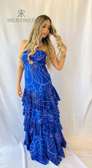 Mujer vistiendo un elegante vestido largo azul con estampado floral de KIKE RODRIGUEZ, ideal para eventos especiales y ocasiones formales.