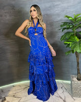 Mujer vistiendo un elegante vestido largo azul con estampado floral de KIKE RODRIGUEZ, ideal para eventos especiales y ocasiones formales.