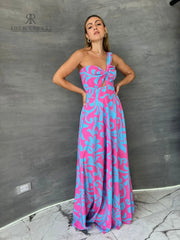 Mujer luciendo un vestido largo floral en rosa y azul de KIKE RODRIGUEZ, destacando elegancia y estilo para eventos especiales.