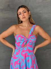 Mujer luciendo un vestido largo floral en rosa y azul de KIKE RODRIGUEZ, destacando elegancia y estilo para eventos especiales.