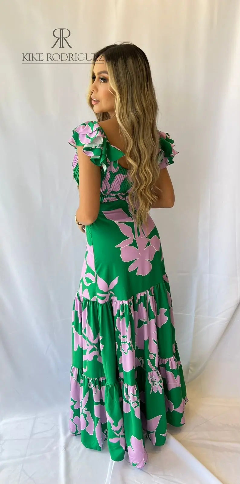 Mujer vistiendo un elegante vestido largo verde estampado floral de KIKE RODRIGUEZ, ideal para eventos especiales y ocasiones elegantes.