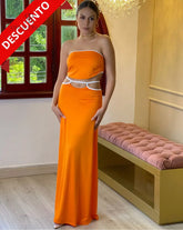 Mujer con elegante vestido naranja con detalles blancos en oferta de KIKE RODRIGUEZ, ideal para eventos y ocasiones especiales.