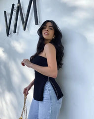 Mujer vistiendo la blusa negra strapless Paulina, combinada con jeans de corte recto, destacando un estilo moderno y elegante