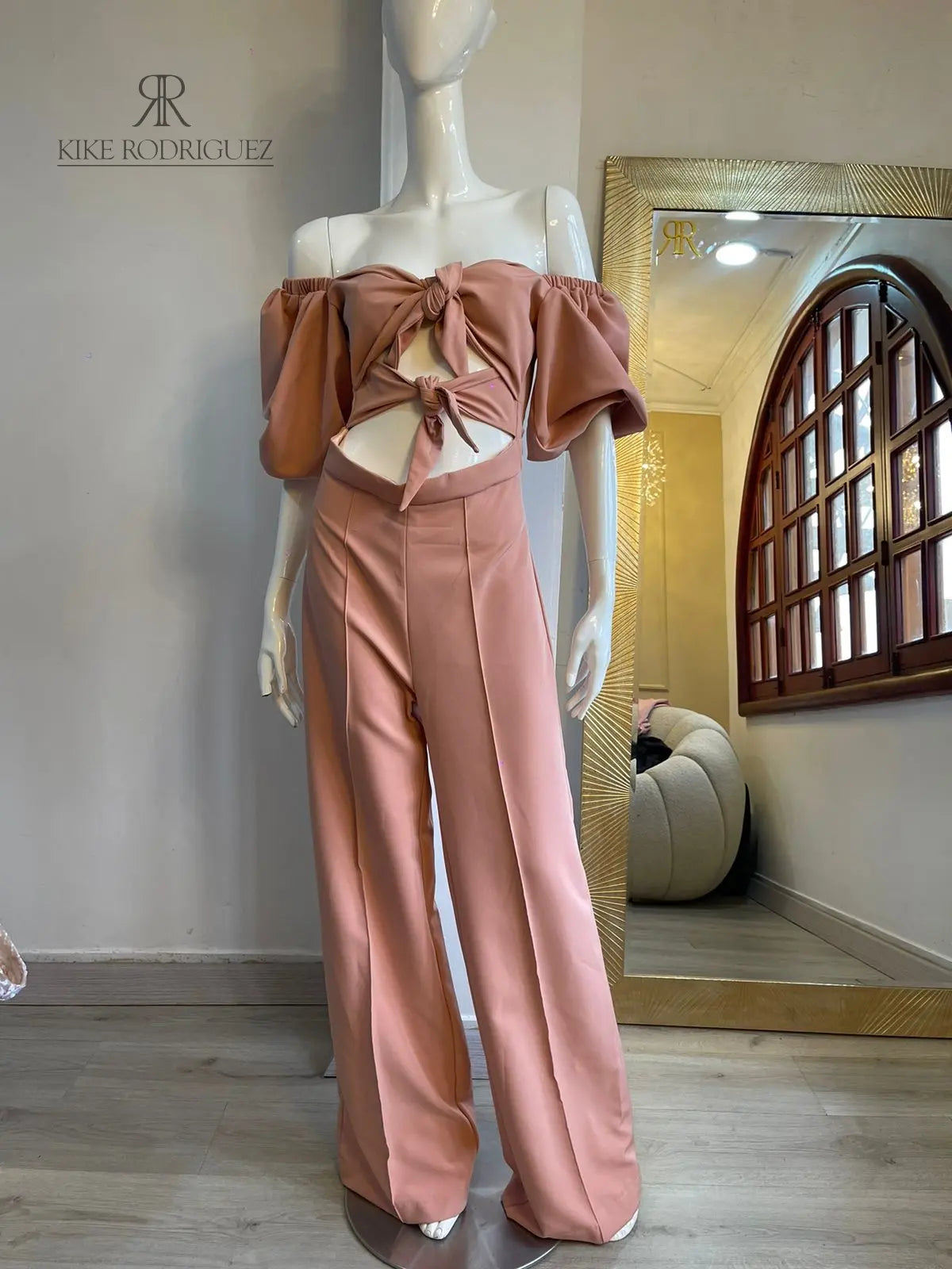 Conjunto rosa con crop top de nudo frontal y pantalón de pierna ancha, ideal para eventos casuales y elegantes
