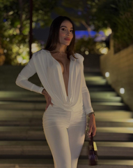 Mujer usando enterizo blanco Nova Cherry de la colección Orión de KIKE RODRIGUEZ, con escote pronunciado y diseño palazzo ideal para eventos elegantes o de noche.