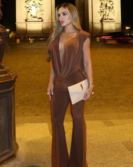 Mujer usando enterizo mocca con escote profundo drapeado y pantalón bota ancha, posando frente al Arco del Triunfo – KIKE RODRIGUEZ