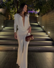 Mujer usando enterizo blancoNova Cherry de la colección Orión de KIKE RODRIGUEZ, con escote pronunciado y diseño palazzo ideal para eventos elegantes o de noche.