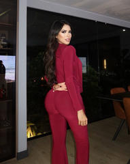 Mujer usando enterizo rojo profundo Nova Cherry de la colección Orión de KIKE RODRIGUEZ, con escote pronunciado y diseño palazzo ideal para eventos elegantes o de noche.