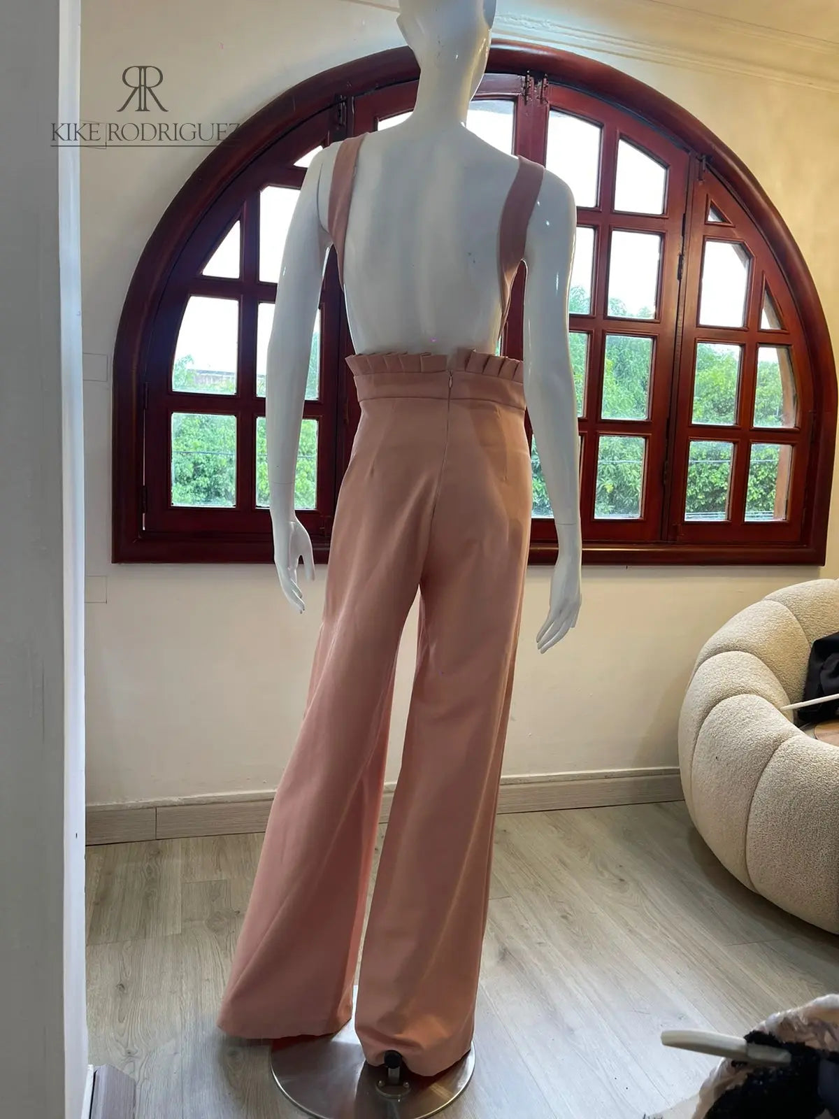 Vista lateral del enterizo rosa mostrando detalles florales y diseño de pierna ancha ideal para eventos formales