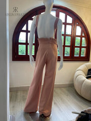 Vista lateral del enterizo rosa mostrando detalles florales y diseño de pierna ancha ideal para eventos formales