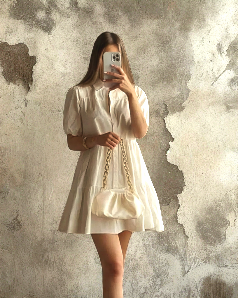 Mujer luciendo el Vestido Blanco Alexandra de Kike Rodriguez, ideal para eventos elegantes y casuales, combinado con un bolso blanco y zapatillas deportivas.