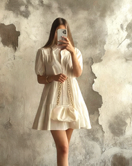 Mujer luciendo el Vestido Blanco Alexandra de Kike Rodriguez, ideal para eventos elegantes y casuales, combinado con un bolso blanco y zapatillas deportivas.